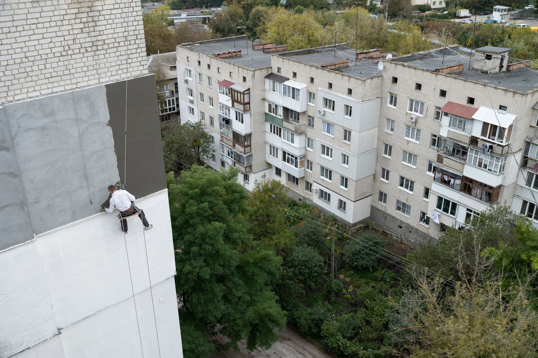 Rope access technician working on a building facade at height