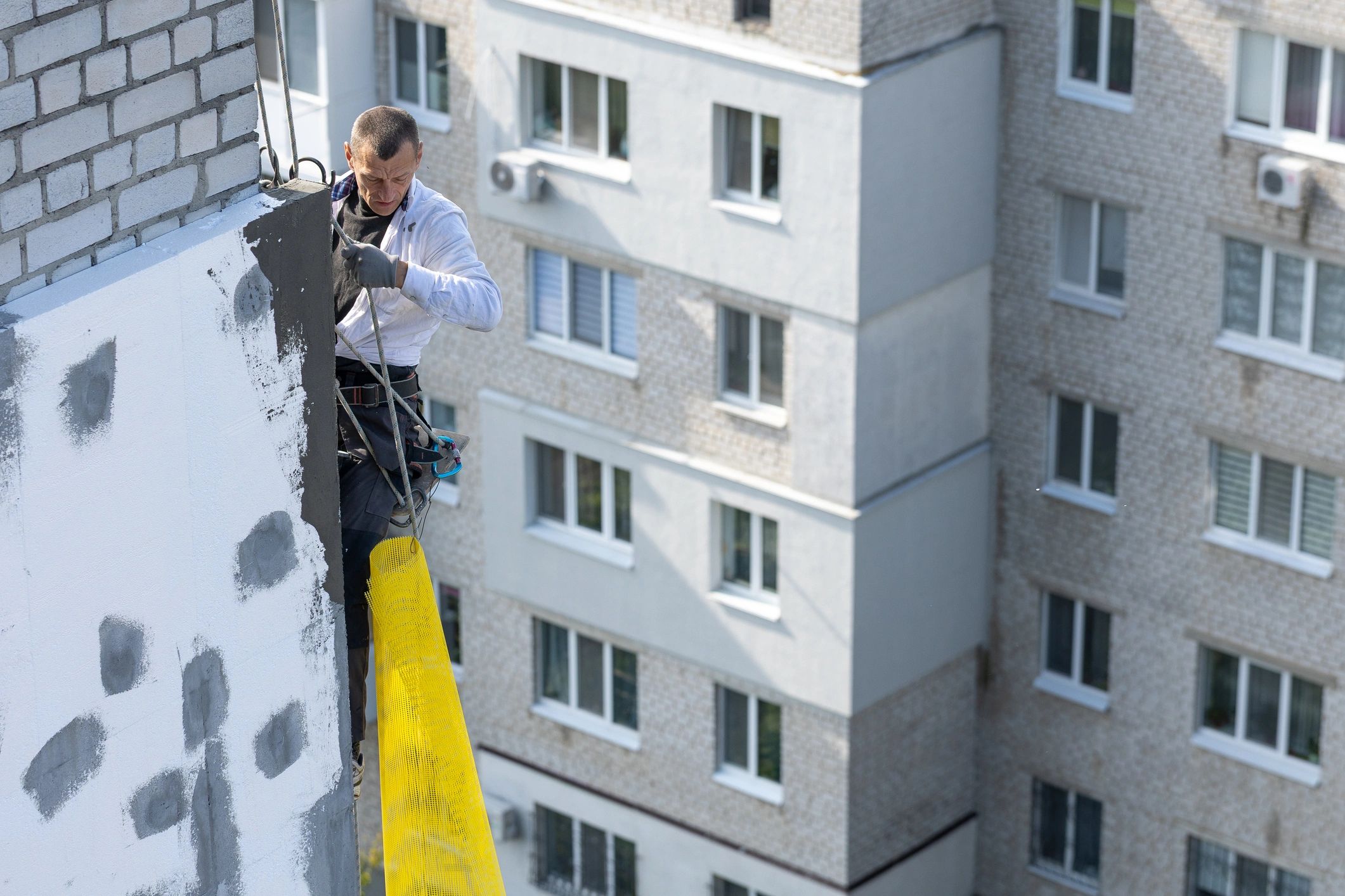 Rope access worker suspended outside a building during facade work
